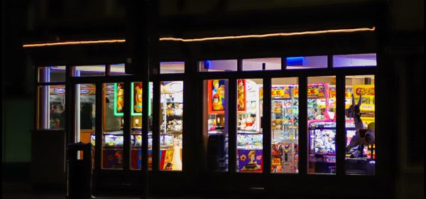 A street scene at night and the bright colourful lights of an amusement arcade