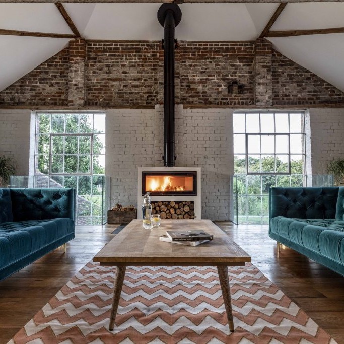 Interior of a sitting room at Roseyard with brick walls and an open fire